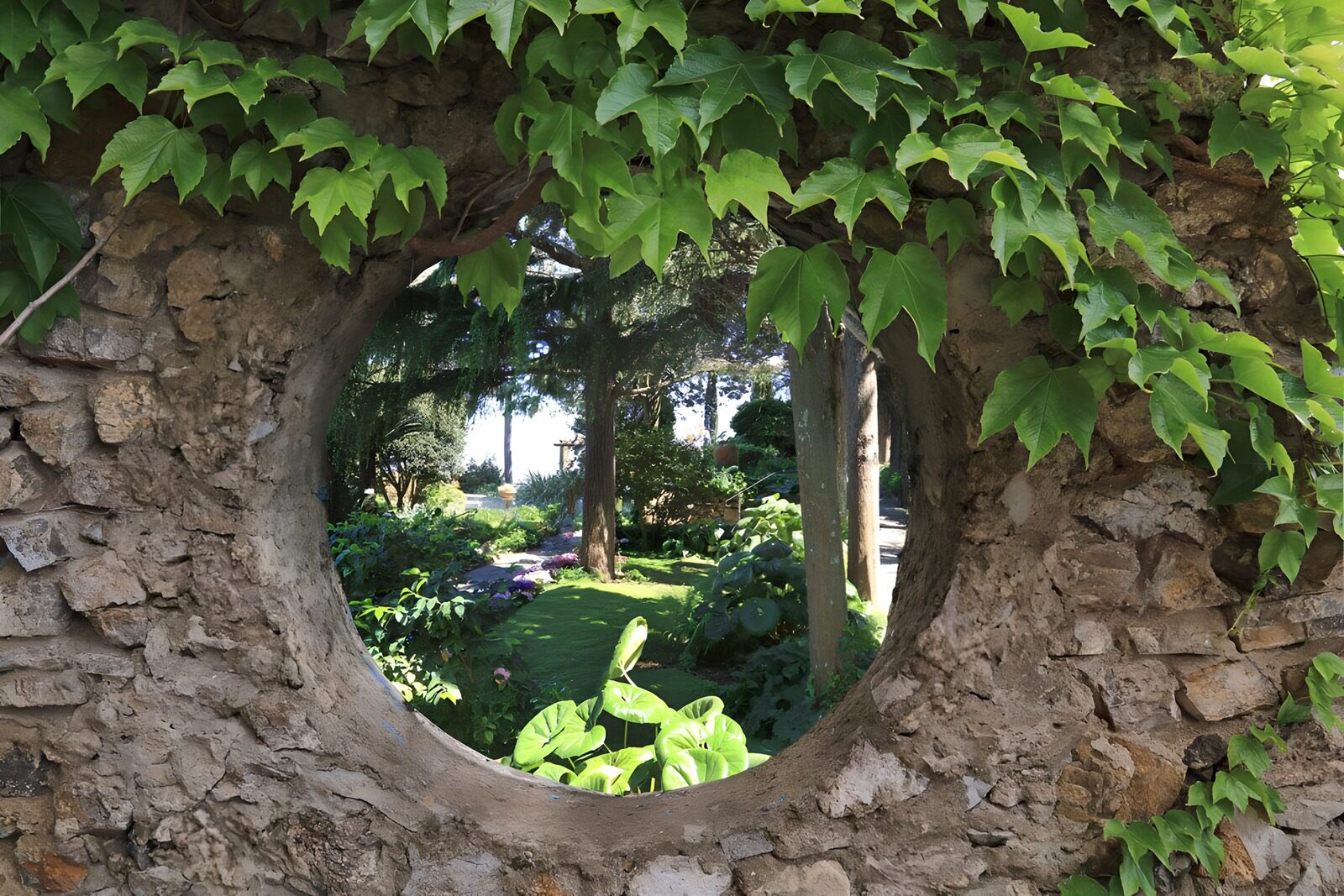 OCUK42609: Round hole in brick wall with lookout at garden, covered with ivy