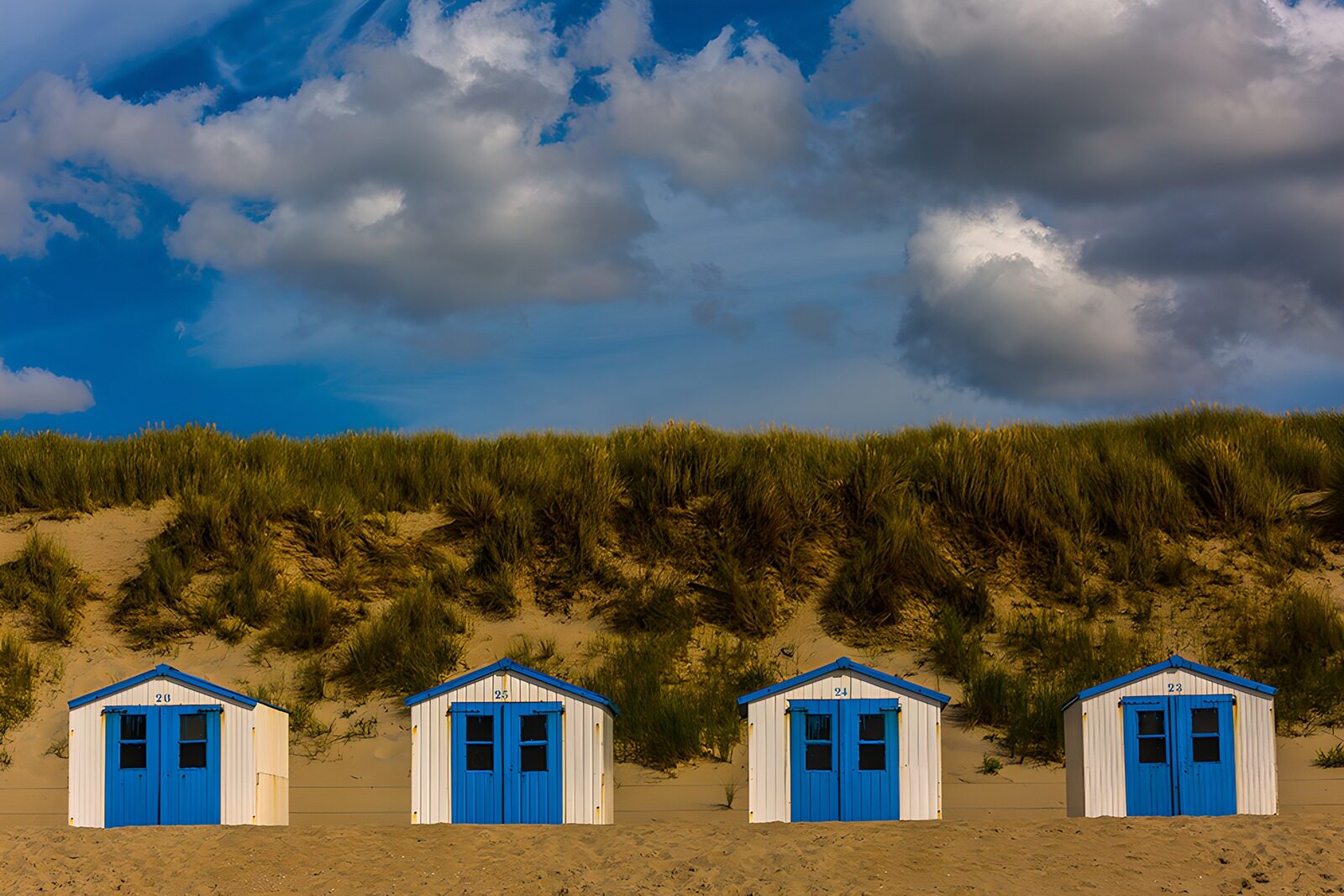 OCUK95466: Coastal Beach Huts under a Dramatic Sky