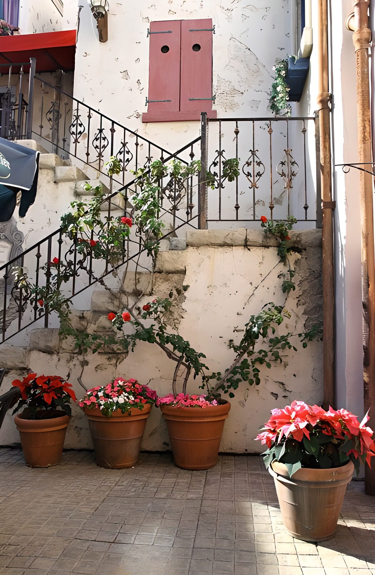 Alms house with steps, with flowers and shutters of the house