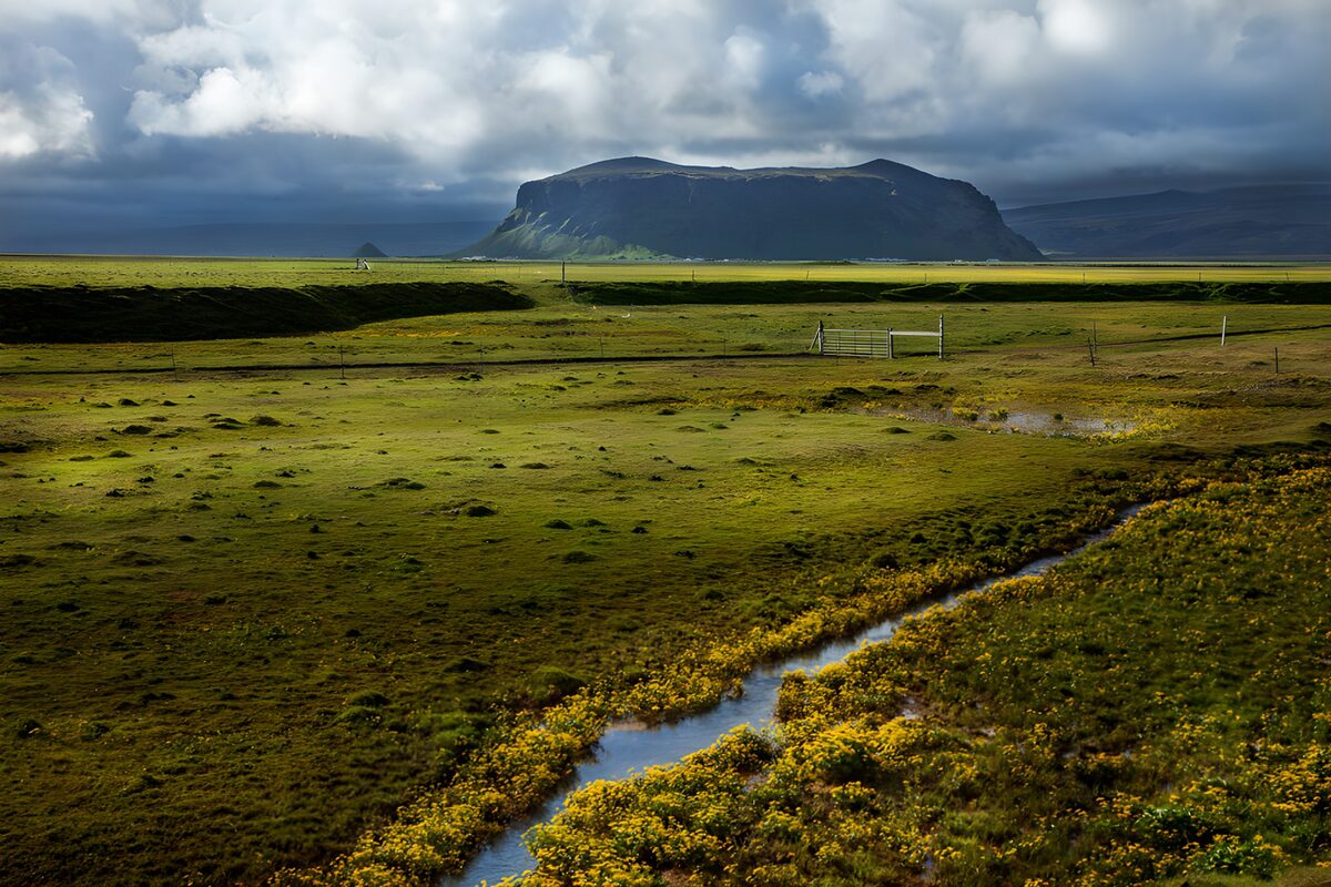 OCUK25027: Lush Green Fields Under Dramatic Skies