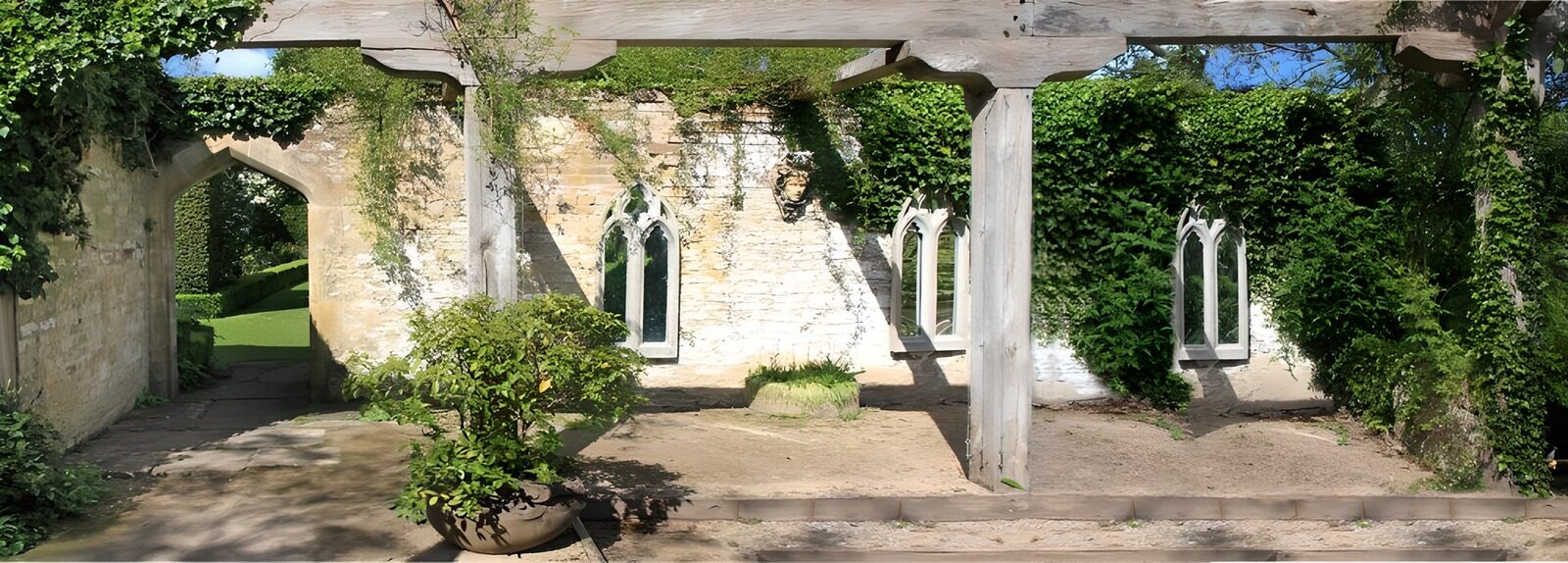 OCUK42829: Open sky patio with an old brick wall filled with an open doorway and several windows