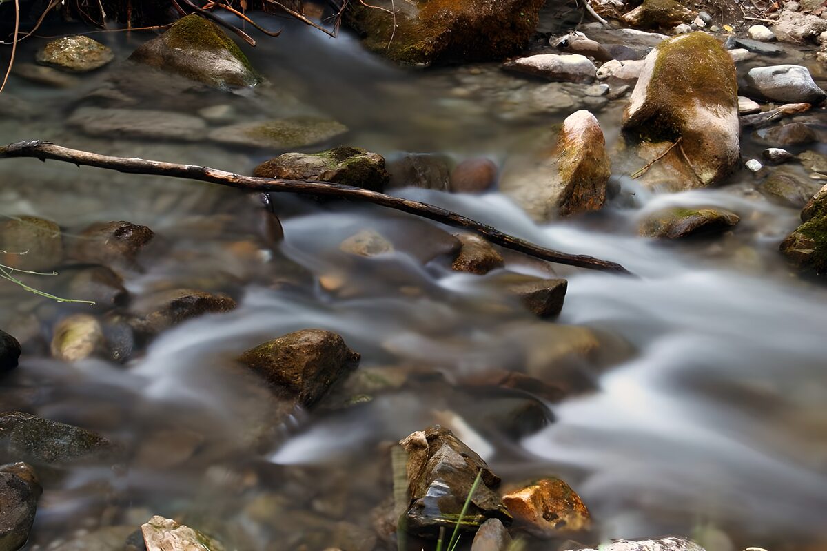 OCUK51033: Serene River Flow Among Smooth Stones