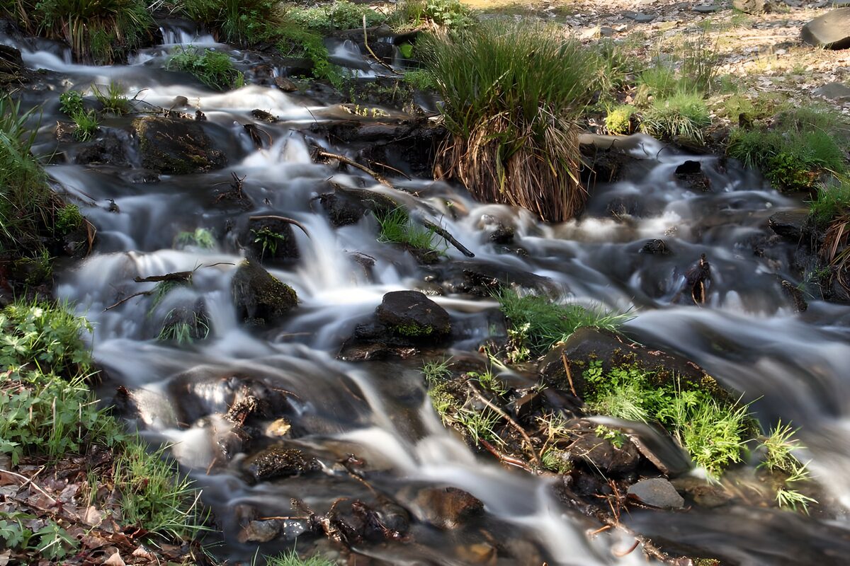 OCUK33200: Serene Stream Over Rocky Bed