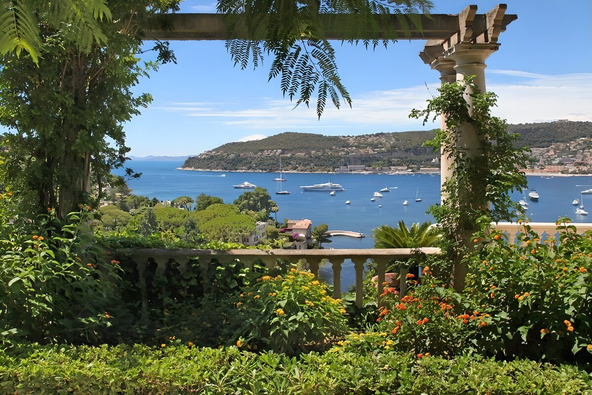 Balcony with flowers and a view on the ocean and boats