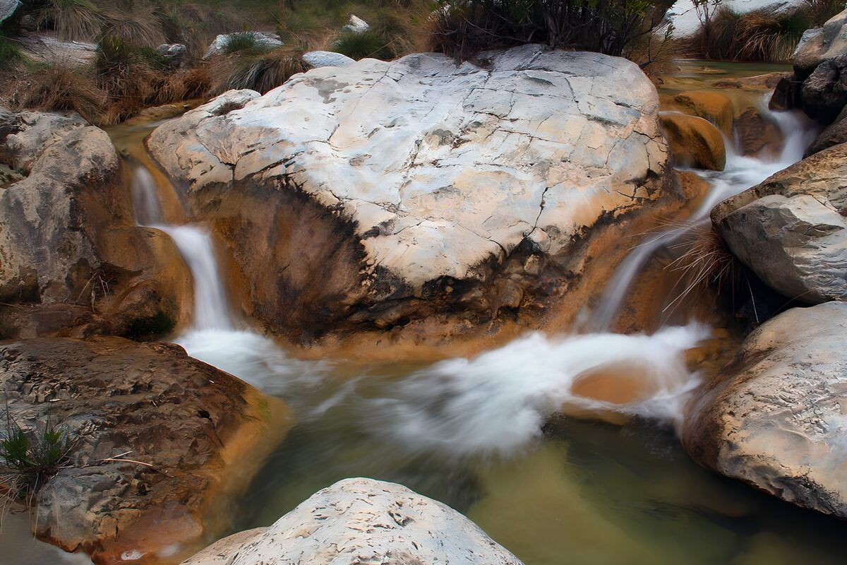 OCUK16603: Serene Stream Over Rocky Terrain