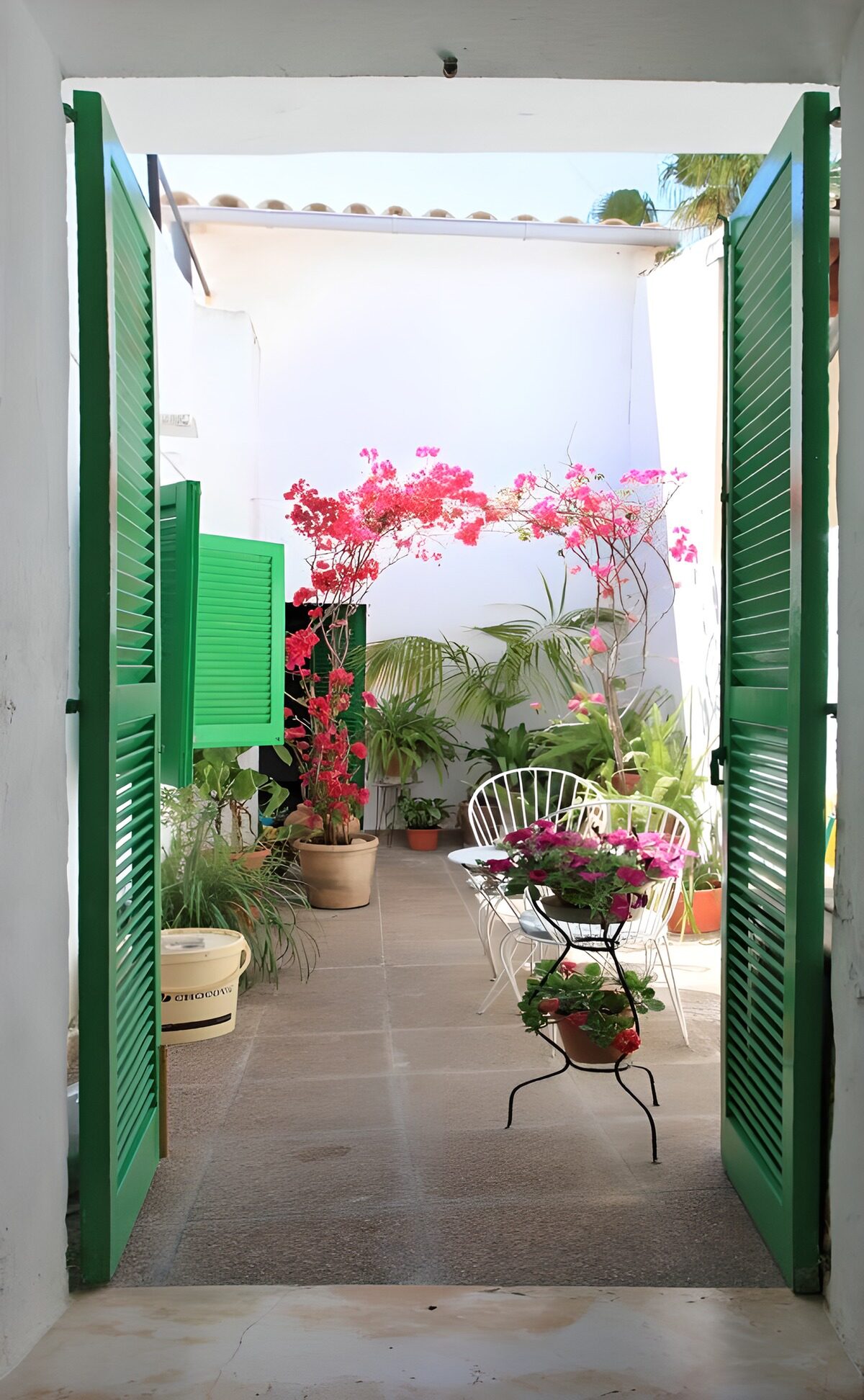 Open green shutters overlooking a patio