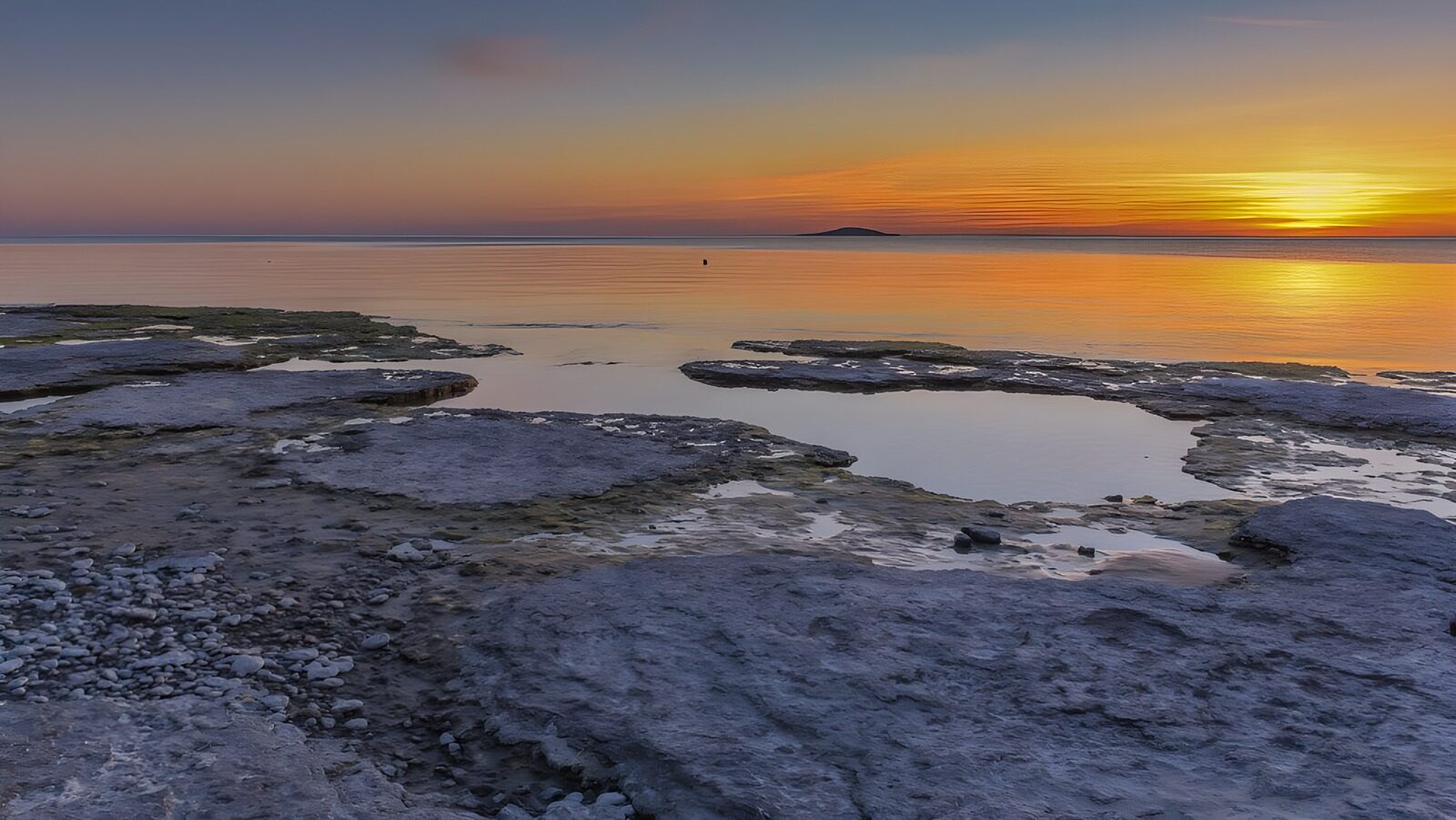 OCUK94391: Serene Sunset Over Rocky Shoreline