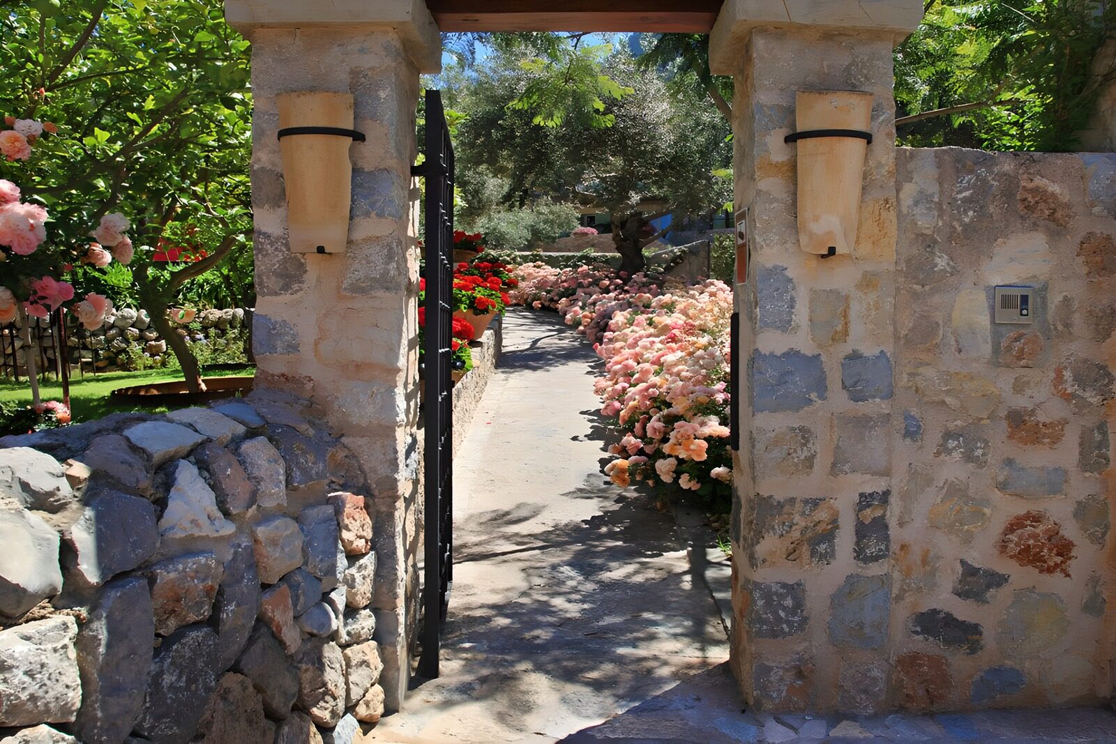 OCUK23194: Old wall with a gate, an iron fence and pink flowers