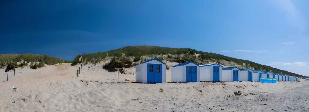 OCUK76737: Coastal Beach Huts Under a Blue Sky