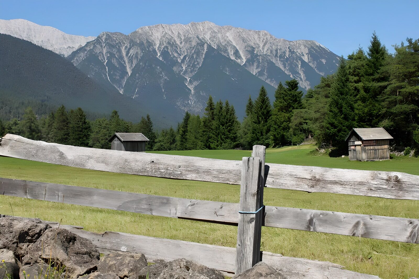 OCUK90931: Stables behind gate in alpine meadow