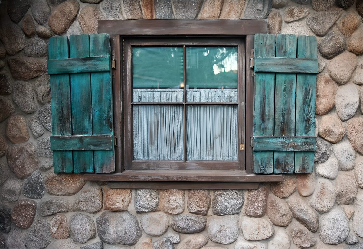 Cottage with window made of boulders and green shutters
