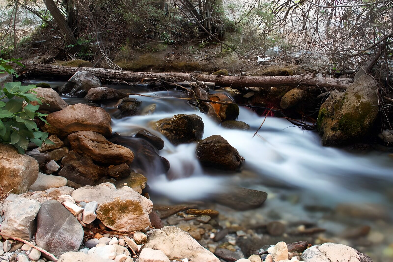 OCUK38754: Serene Stream Flowing Through Rocky Terrain