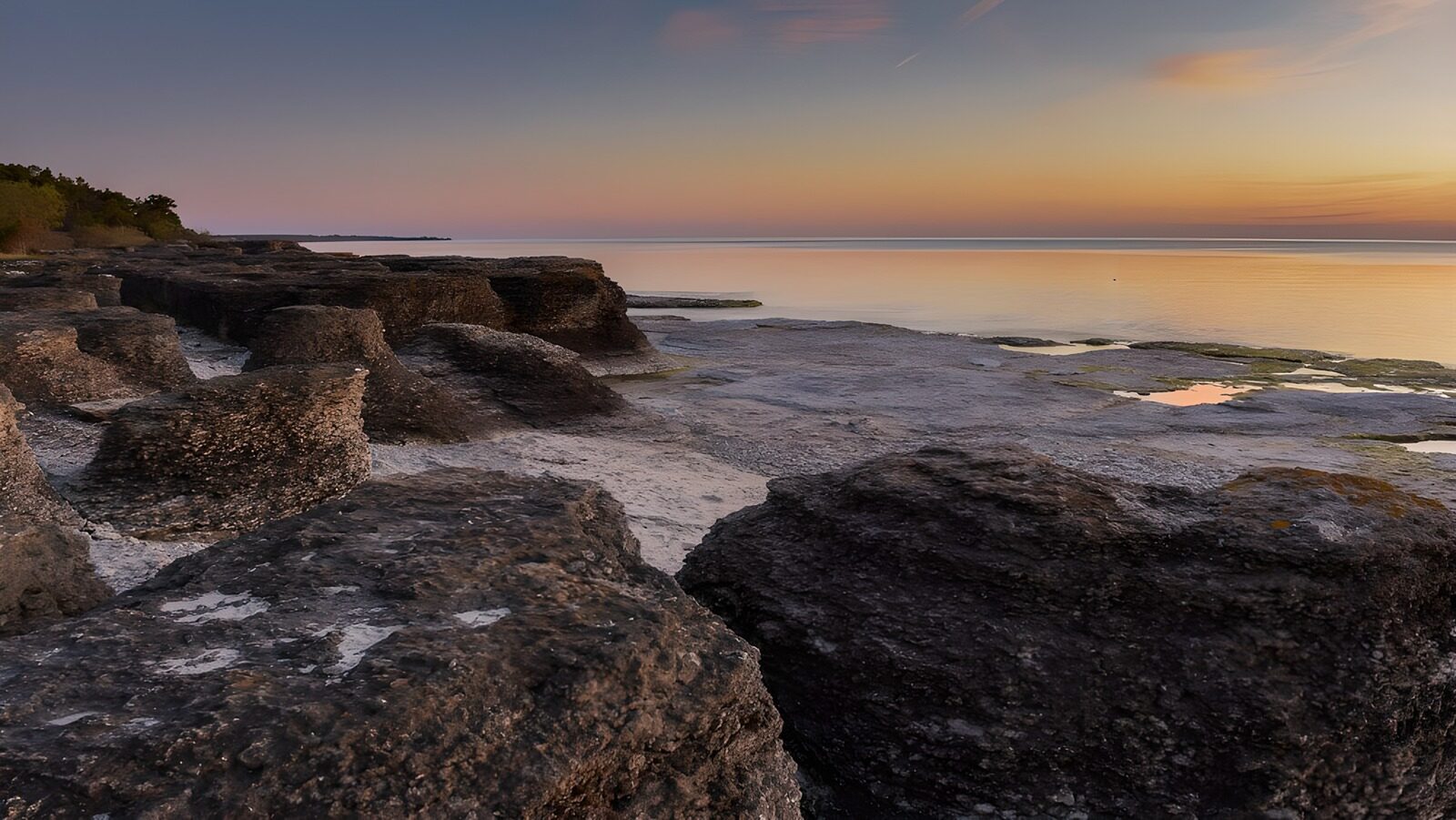 OCUK30460: Tranquil Sunset Over Rocky Shoreline
